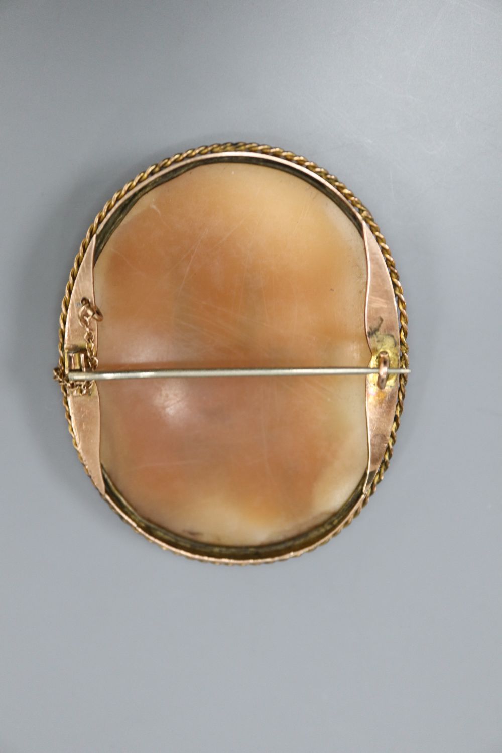 A modern quadruple strand cultured pearl bracelet, 15.8cm and a yellow metal mounted oval cameo shell brooch, 52mm.